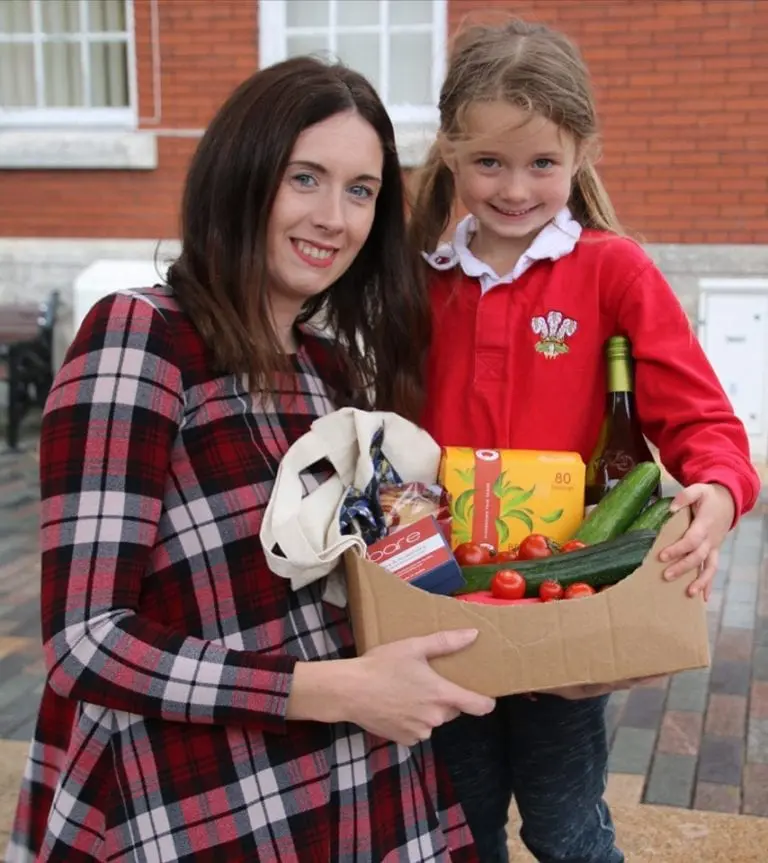 Image showing mother and young girl holding cardboard box of plastic free fruit and vegetables