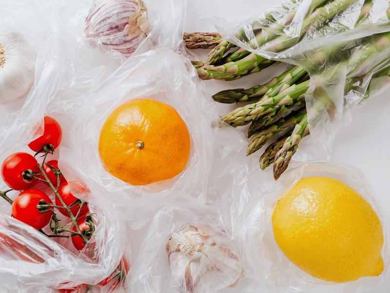 Stylised image of fruit and vegetables wrapped in transparent plastic.