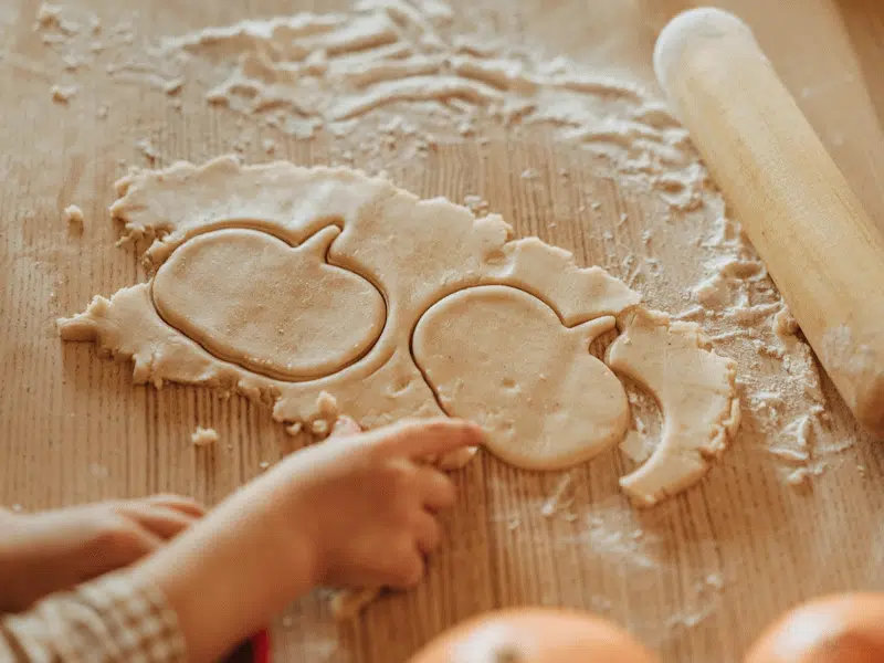 Baking pumpkin-shaped biscuits.