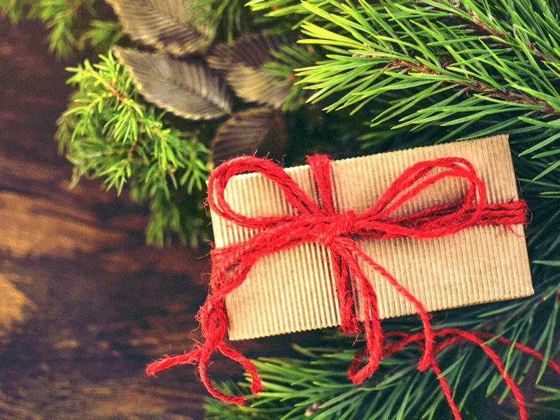 Christmas gift wrapped in brown paper and tied with red string.