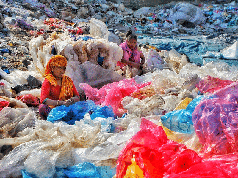 Women sorting piles of plastic waste.
