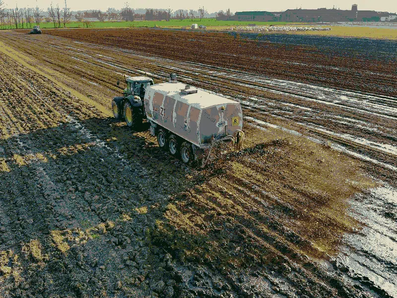 Vehicle spraying sewage sludge on farmland.