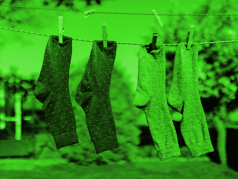 Two pairs of socks hanging from a washing line.