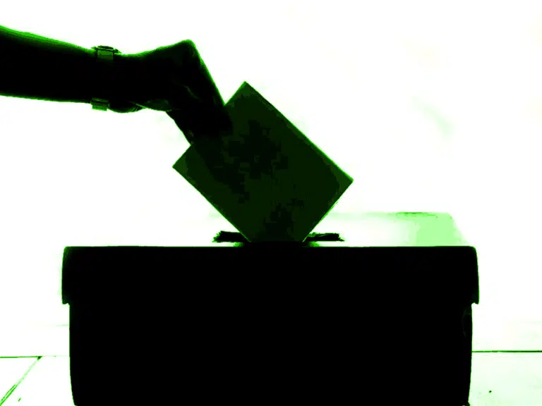 General Election 2024 - silhouette of person putting voting slip into ballot box.