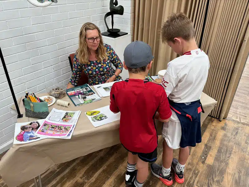 Anne Maund and two young boys at a stall during the plastic-free craft activities event in Mold on 3 August 2024.